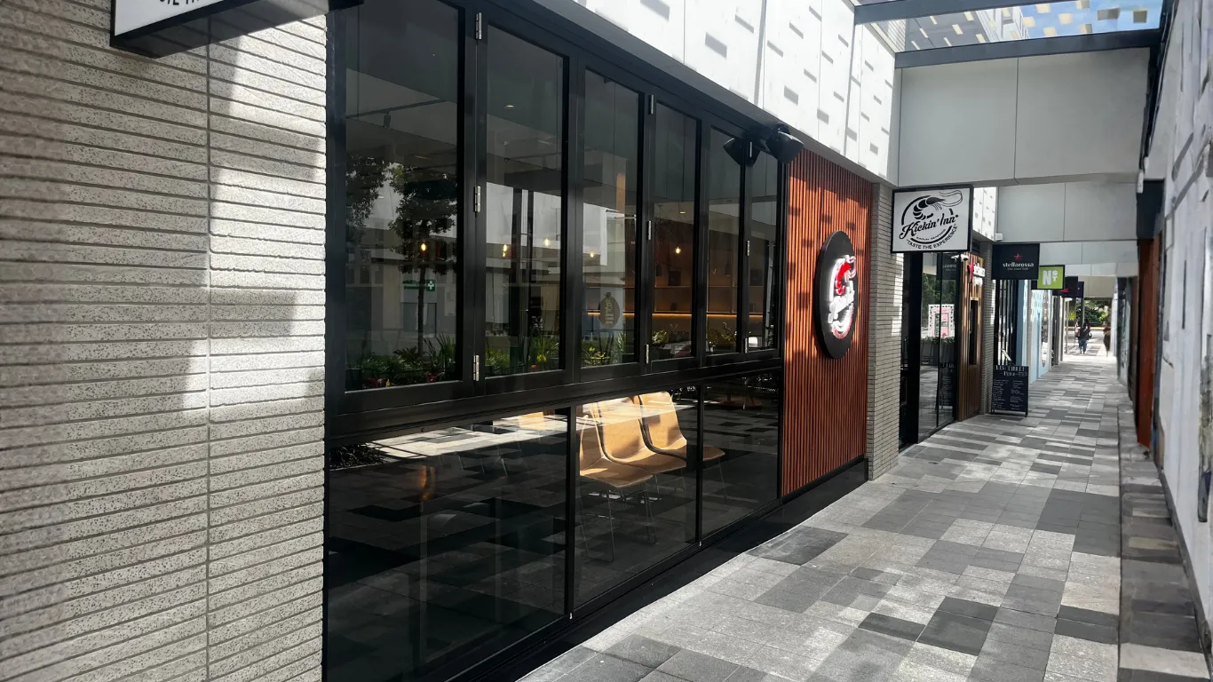 Black framed commercial glazing installed on a restaurant exterior.